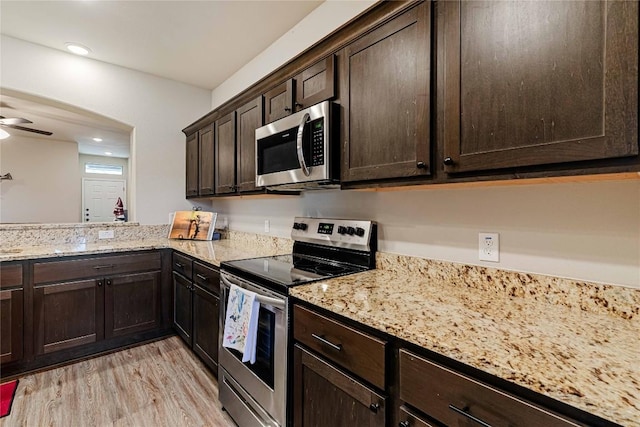 kitchen with stainless steel appliances, light wood-type flooring, ceiling fan, and dark brown cabinets