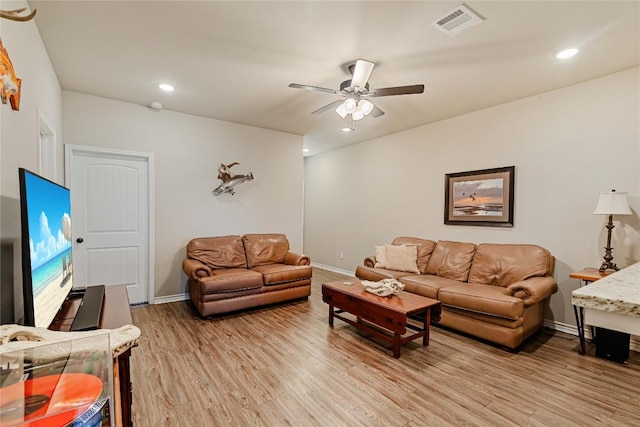 living area featuring a ceiling fan, light wood-type flooring, visible vents, and baseboards