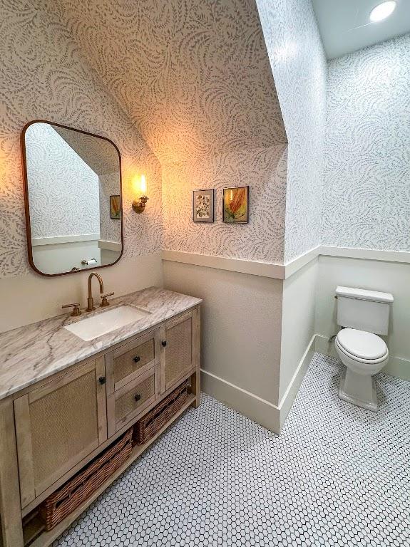 bathroom with wallpapered walls, baseboards, toilet, tile patterned floors, and vanity