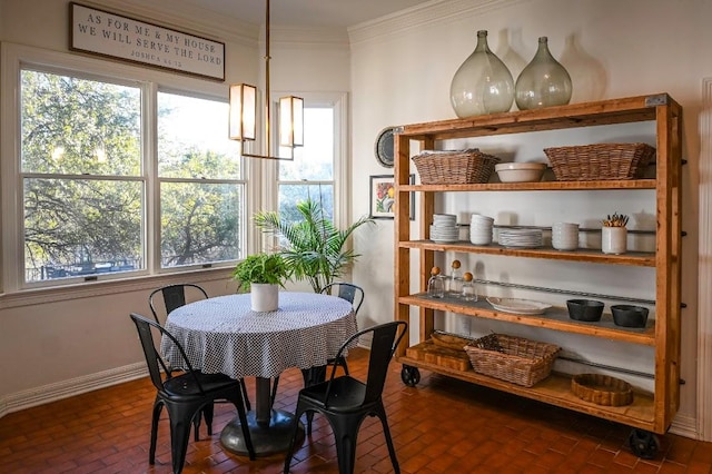 dining room with ornamental molding, brick floor, plenty of natural light, and baseboards