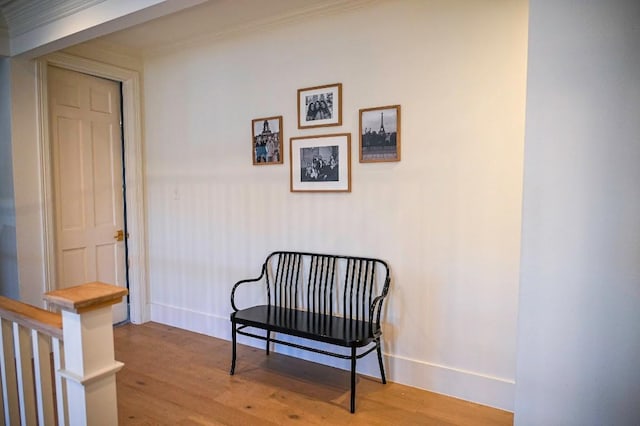 sitting room with ornamental molding, baseboards, and light wood finished floors