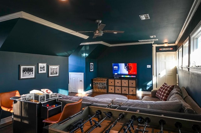 home theater featuring lofted ceiling, visible vents, a ceiling fan, wood finished floors, and baseboards