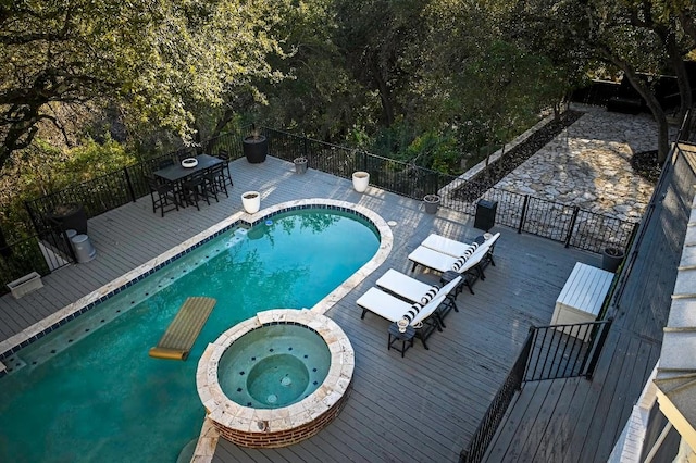 view of swimming pool with outdoor dining space, a pool with connected hot tub, and a wooden deck