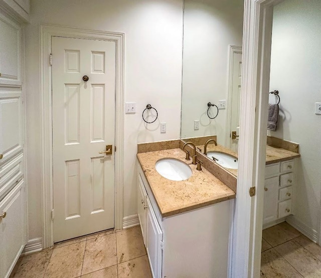 bathroom with tile patterned floors, baseboards, and vanity