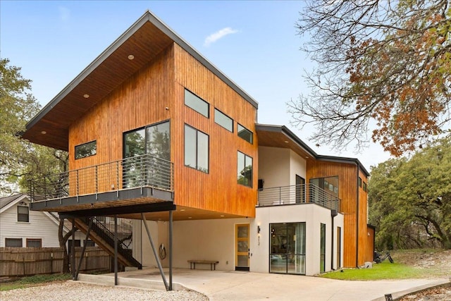 rear view of property with stairway, a patio area, and fence