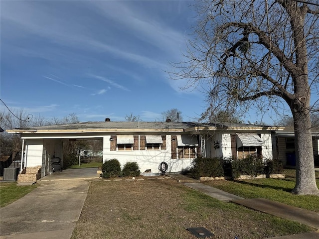 ranch-style house with concrete driveway, a carport, a front lawn, and brick siding