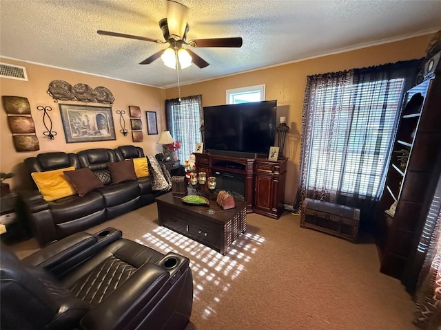 living area with visible vents, ceiling fan, a textured ceiling, and carpet flooring