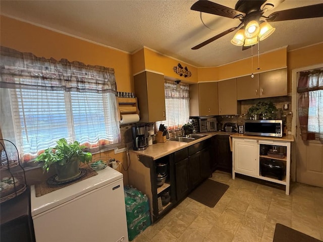 kitchen with light floors, light countertops, stainless steel microwave, a textured ceiling, and fridge