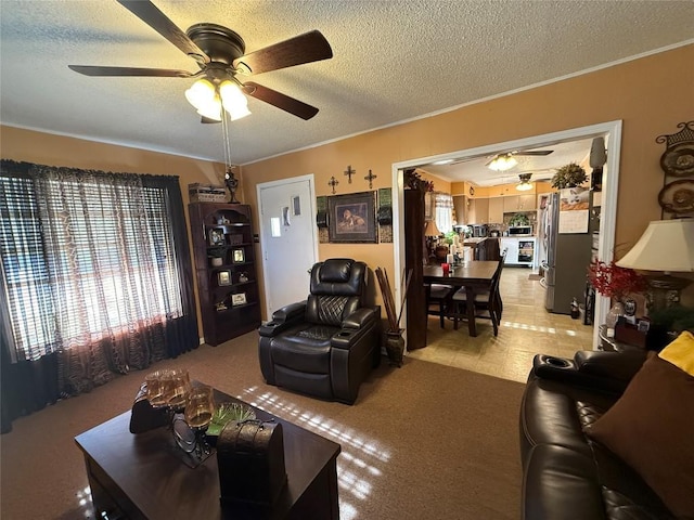 living room featuring a textured ceiling, ceiling fan, and crown molding