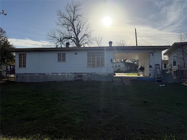 back of house with a carport and a lawn