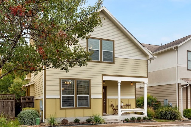 view of front of home with covered porch and fence