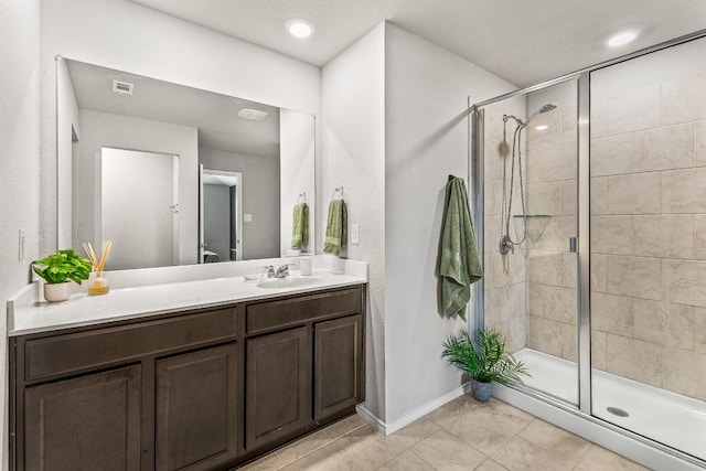 full bathroom featuring a stall shower, vanity, and baseboards