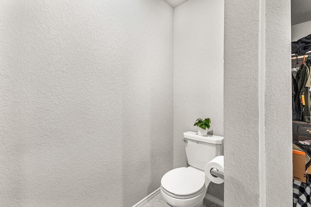 bathroom with a textured wall and toilet