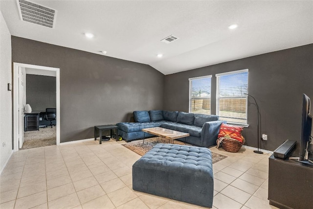 living area with lofted ceiling, visible vents, baseboards, and light tile patterned floors