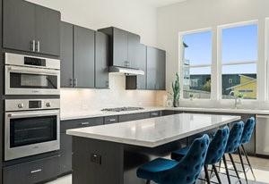 kitchen featuring appliances with stainless steel finishes, a kitchen breakfast bar, a center island, extractor fan, and light countertops