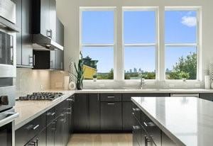 kitchen featuring a sink, tasteful backsplash, stainless steel appliances, and light countertops