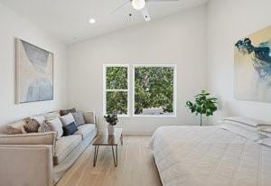 bedroom with vaulted ceiling, wood finished floors, a ceiling fan, and recessed lighting