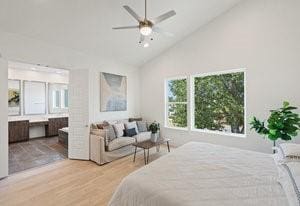 bedroom featuring high vaulted ceiling, ensuite bath, and wood finished floors