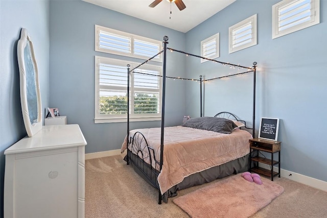 bedroom with light colored carpet, baseboards, and ceiling fan