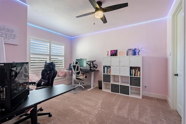 carpeted office featuring baseboards and a ceiling fan