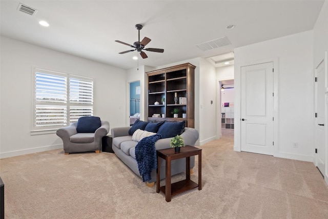 living area with recessed lighting, visible vents, light colored carpet, and baseboards