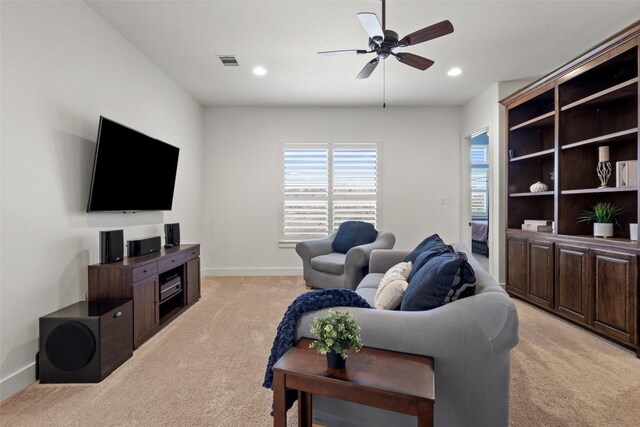 living room with a ceiling fan, visible vents, baseboards, recessed lighting, and light colored carpet