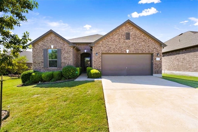 view of front of property with a garage, driveway, brick siding, and a front yard