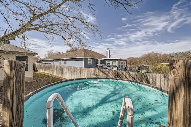 view of swimming pool with a fenced backyard