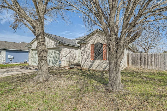 view of front of property featuring a garage, concrete driveway, a front yard, and fence