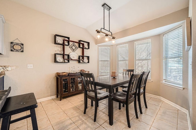 dining room with lofted ceiling, baseboards, and light tile patterned floors