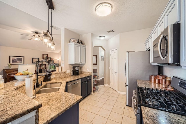 kitchen with light stone counters, light tile patterned floors, visible vents, appliances with stainless steel finishes, and a peninsula