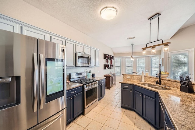 kitchen featuring decorative light fixtures, light tile patterned floors, stainless steel appliances, visible vents, and a sink