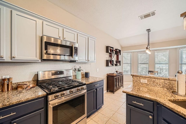 kitchen with pendant lighting, visible vents, appliances with stainless steel finishes, light tile patterned flooring, and vaulted ceiling