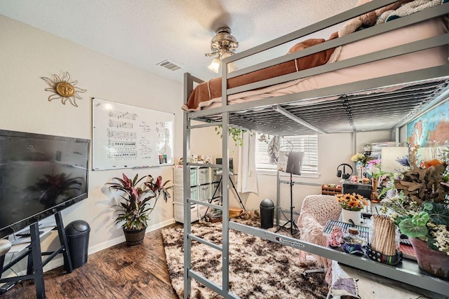 bedroom with baseboards, visible vents, and wood finished floors