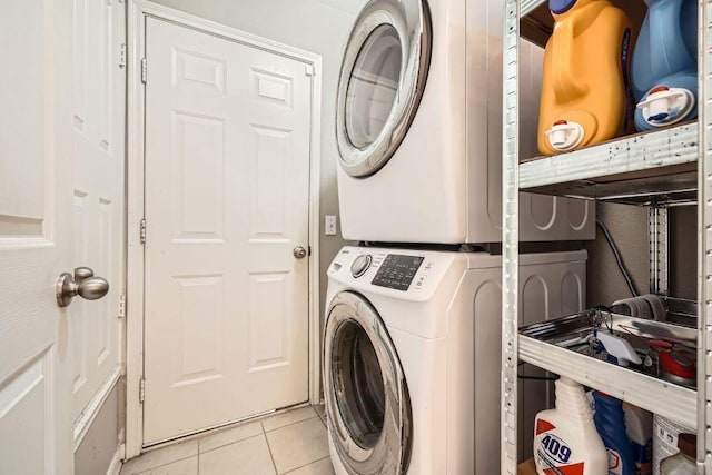 clothes washing area with light tile patterned floors, laundry area, and stacked washer / dryer