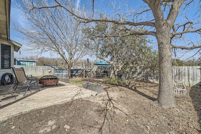 view of yard featuring a fire pit, a patio area, and a fenced backyard