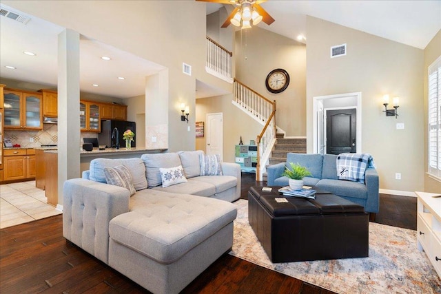 living area featuring visible vents, stairway, and wood finished floors