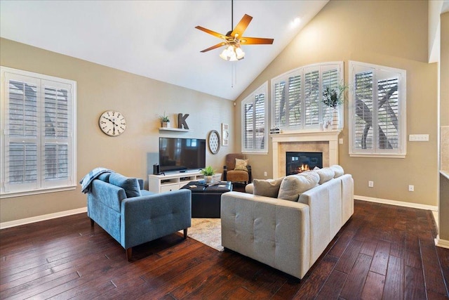 living room featuring dark wood-style floors, baseboards, high vaulted ceiling, and a glass covered fireplace