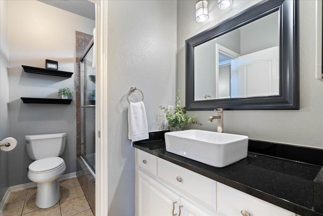 bathroom with toilet, tile patterned floors, baseboards, and vanity