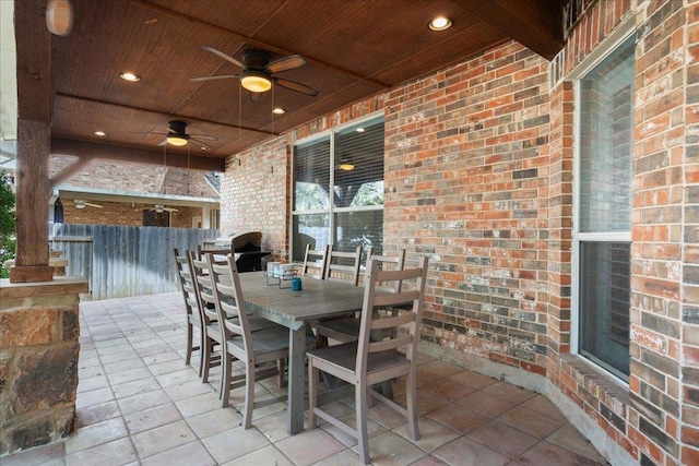 view of patio with outdoor dining area, fence, and a ceiling fan