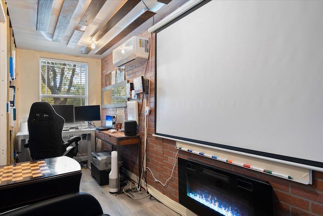 office space with a glass covered fireplace, a wall mounted AC, and wood finished floors