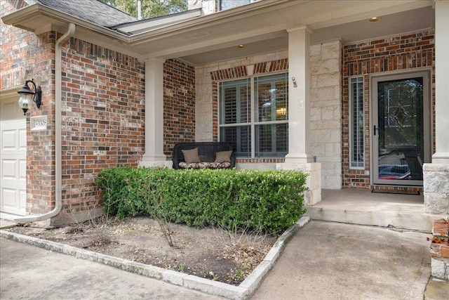 property entrance featuring an attached garage, covered porch, a shingled roof, and brick siding