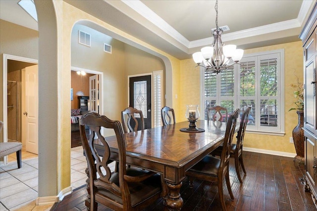 dining space with visible vents, arched walkways, a chandelier, and crown molding