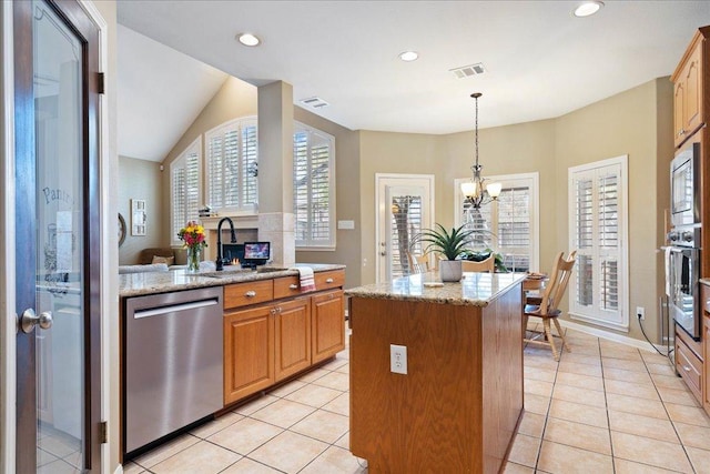 kitchen with light tile patterned floors, stainless steel appliances, a sink, and a center island