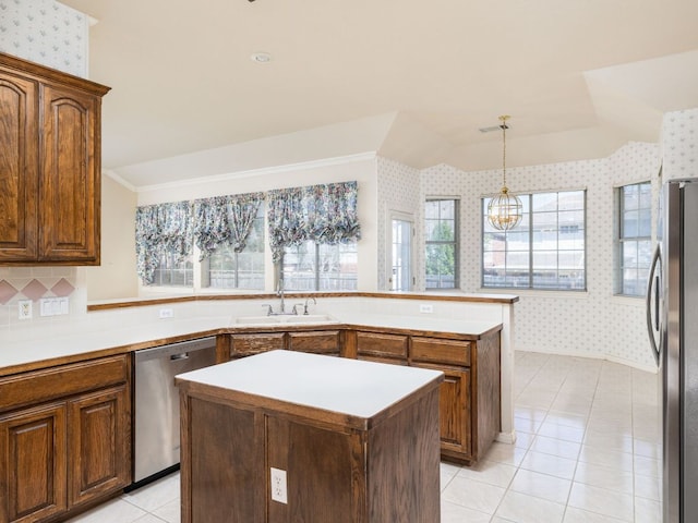 kitchen featuring wallpapered walls, appliances with stainless steel finishes, a sink, and a center island