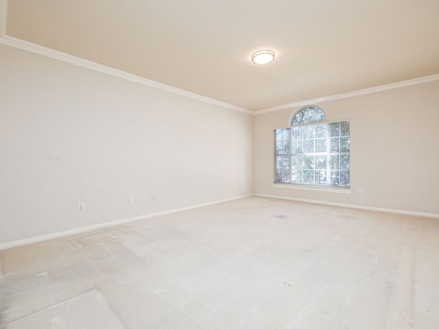 unfurnished room featuring baseboards, ornamental molding, and light colored carpet