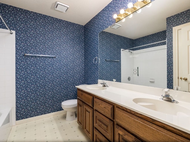 full bathroom featuring toilet, wallpapered walls, double vanity, and a sink