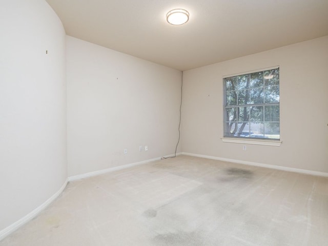 unfurnished room with carpet and baseboards