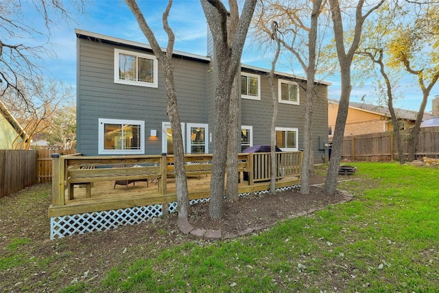 back of property with a fenced backyard, a yard, and a wooden deck