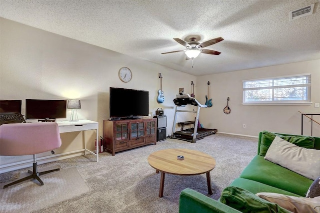 living room featuring ceiling fan, a textured ceiling, carpet, and visible vents